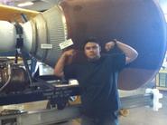 John G. - Cal Poly Aeronautical Engineering student flexing in front of an engine